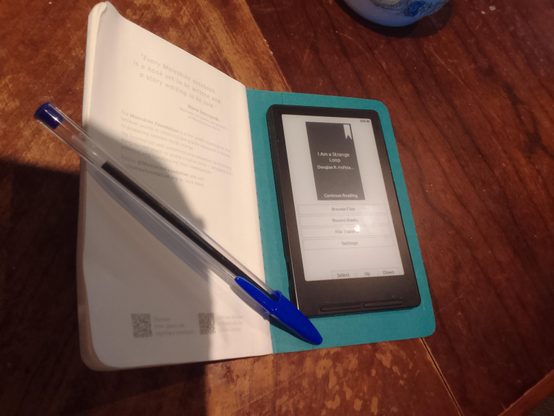Moleskine notebook and Xteink4 ereader on a table.
